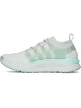 Championes Under Armour modelo UA W Phantom X, de color blanco con detalles en verde menta. Presentan parte superior de tejido transpirable, estructura de TPU translúcido en el mediopié con el logo de la marca, entresuela acolchada y suela de goma con tacos para tracción.