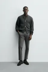 Pantalón chino de corte ajustado, color beige, con bolsillos laterales y bolsillos traseros de vivo. Cuenta con cierre frontal de cremallera y botón.