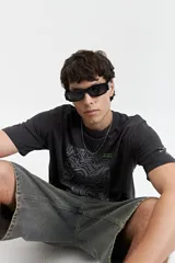 Remera de manga corta color gris oscuro, con cuello redondo, fit regular y estampa frontal de líneas topográficas con detalles en verde.