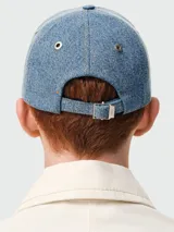 Gorra de jean celeste con logo bordado en marrón.