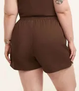 Short color beige de sarga de algodón, con cintura elástica, lazo ajustable y bolsillos laterales. Corte holgado.