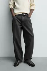 Jeans baggy fit de corte holgado en color negro con efecto lavado, confeccionados en denim de algodón rígido, con diseño clásico de cinco bolsillos y cierre frontal con cremallera y botón.