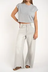 Remera gris de algodón con poliéster, corte crop, mangas cortas y bolsillo en el pecho.