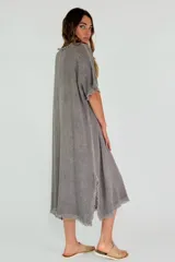 Vestido midi color amarillo, de corte suelto y manga corta, con ruedo desflecado.