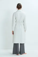 Bata de estar por casa con diseño acolchado, cuello solapa, mangas largas y lazo ajustable en la cintura. Cuenta con bolsillos frontales aplicados.
