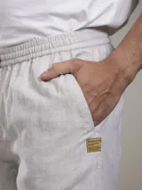 Pantalón jogger color beige de lino y algodón, con cintura elástica y cordón ajustable multicolor.