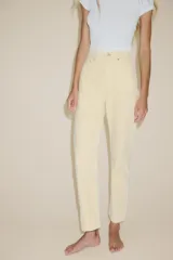 Jeans de mujer, tiro alto, color azul medio con efecto desgastado (lavado claro en muslos y oscuro en bordes). Corte recto y ancho (mom fit) con cinco bolsillos y cierre frontal de botón y cremallera.