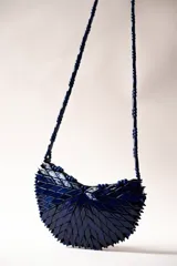 Cartera semicircular de diseño estructural, hecha a mano, con textura en relieve y correa de cuentas de madera azul.