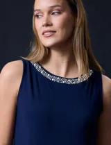 Vestido azul marino de seda fría, sin mangas y escote a la base con aplique de perlas.