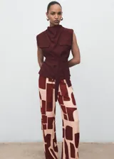 Pantalón fluido de tiro medio con estampado geométrico en tonos bordó y beige, cintura elástica con cordón ajustable, bolsillos laterales y diseño de pernera recta.