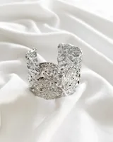 Pulsera rígida plateada con textura irregular.