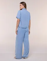 Camisa de corte recto y calce fluido color celeste, confeccionada en lyocell con efecto lavado, cuello camisero tradicional, botones a tono, dos bolsillos aplicados en el pecho y mangas cortas.