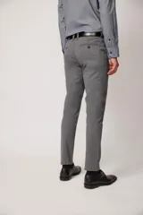 Pantalón de vestir color beige, confeccionado en algodón con spandex. Corte recto, con bolsillos laterales y traseros. Se ajusta a la cintura con cinturón de cuero trenzado en tonos azul y beige.