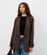 Blazer sastrero de corte alargado con estampado de cuadros pequeños en tonos marrones. Presenta cuello con solapa, cierre frontal con dos botones y mangas largas.