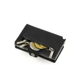 Billetera compacta marca Baleine, modelo Kansas Zipper Full, confeccionada en cuero genuino color negro con estructura interna de aluminio. Cuenta con sistema de deslizamiento para tarjetas, protección RFID, compartimento para billetes y cierre con broche a presión.