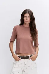 Remera de algodón color marrón, con cuello redondo y mangas cortas, de corte recto y largo a la cintura.