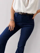 Jean oxford de tiro alto en denim azul oscuro, con calce ajustado en cadera y muslos, y botamanga amplia. Confeccionado en tejido elástico que se adapta a la silueta.