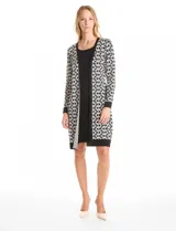 Vestido midi de tejido de punto con diseño integrado que simula un conjunto de vestido negro liso con un cárdigan largo estampado de eslabones geométricos en blanco y negro. Presenta escote redondo y mangas largas.