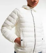 Campera ultra leve Blue Steel, confeccionada en poliamida, con diseño de gajos, capucha, cierre frontal por cremallera, bolsillos laterales con botones y elástico en los puños.