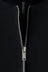 Campera negra de felpa con efecto neopreno, corte oversized y hombros caídos. Presenta cuello redondo, cierre frontal metálico, bolsillos delanteros insertados y elástico revestido en puños y bajo.