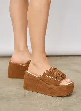 Sandalia tipo zueco color marrón de gamuza con plataforma alta, capellada con costuras decorativas en contraste y detalles de flecos.