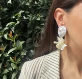 Aros colgantes con base de nácar blanco y pieza colgante con forma de flor de nácar blanco.