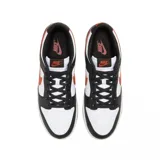 Championes Nike Dunk Low Retro con diseño tricolor en blanco, negro y naranja. Presentan una base de cuero blanco con superposiciones en cuero negro, el icónico swoosh lateral en color naranja y suela de goma naranja.