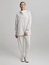 Sweater jogger largo color crema con cuello tortuga.