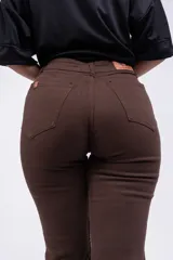 Pantalón tipo oxford de tiro alto, color beige, con diseño de cinco bolsillos y cierre frontal con botón y cremallera.
