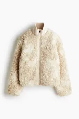 Campera de sherpa suave con cuello elevado acanalado y cierre frontal. Modelo con bolsillos laterales discretos, bolsillo interior y cordones para ajustar en el bajo.