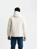 Campera impermeable negra con capucha, cierre frontal, bolsillos frontales con tapa y puños elásticos.