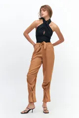 Pantalón de lino color fucsia, de corte relajado con cintura elástica y lazo ajustable. Presenta bolsillos ojal y detalle de presillas con botones en los tobillos que permiten ajustar el ruedo.