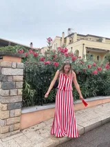 Falda larga tejida a rayas verticales rojas y blancas, con pretina elástica y tajos laterales.