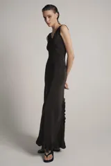 Vestido largo de viscosa en color negro, con escote redondo y tirantes anchos con detalle de volados. Presenta bordados florales a tono en la parte superior y bajo con terminación evasé.