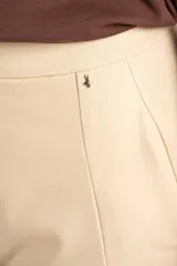 Pantalón de corte baggy y tiro medio, confeccionado en algodón peinado de color arena. Presenta diseño de pierna ancha, cierre frontal con botón y bolsillos laterales.