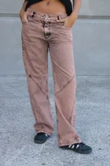 Jean de corte recto y tiro medio, color rosado con efecto acid wash y costuras diagonales en negro.