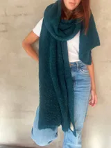 Chal de punto bouclé color marrón claro, hecho de 100% baby alpaca. Tejido suave, esponjoso y cálido, ofrece una textura envolvente y lujosa.