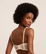 Soutien alargado color piel, confeccionado en encaje floral, con copa hueca y aro, tirantes ajustables y cierre trasero.