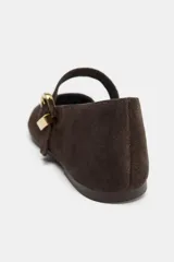 Zapato plano tipo bailarina confeccionado en serraje, con punta redonda y tira delantera ajustable con maxi hebilla metálica dorada.