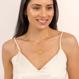 Collar dorado con colgante circular con diseño de ojo y piedras turmalinas multicolor y topacio blanco.