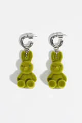 Pendientes de aro plateados con dije colgante en forma de conejo de textura flocada color verde. Cuentan con cierre de presión.