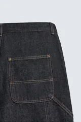 Jeans de hombre relaxed straight fit, color azul oscuro, confeccionados en denim rígido sin prelavados. Presentan cinco bolsillos, bolsillos plastrón y tira multifunción en las perneras. Cierre frontal con cremallera y botón.
