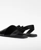Zapato plano destalonado de piel negra con diseño asimétrico y puntera cuadrada. Cuenta con tira elástica en el talón y plantilla Memory Foam.