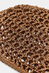 Gorro tipo casquete color marrón, confeccionado con tejido trenzado y diseño calado.