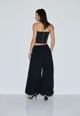 Corset strapless negro con cierre frontal de ganchos metálicos en forma de ancla, con diseño estructurado y dobladillo en punta.