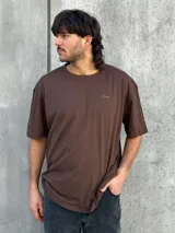 Remera marrón de corte amplio con estampado en la espalda con la palabra 'Perception' y otras frases en color dorado.