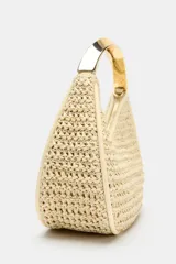 Bolso de mano mini con cuerpo trenzado en color beige y asa rígida metálica dorada. Incluye correa bandolera extraíble y cierre superior de cremallera.