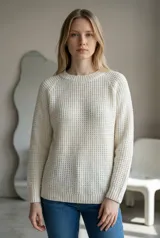 Sweater de tejido de punto con textura tipo waffle, color crudo, de corte clásico con cuello redondo y mangas largas con puños acanalados.