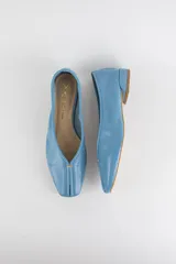 Mocasines de cuero color celeste, con diseño de punta cuadrada, costura central en la capellada y suela plana con taco bajo.