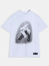 Remera blanca de manga corta de la colección Tini x Under Armour, con cuello redondo y diseño holgado. Cuenta con un gran estampado fotográfico en el centro y una etiqueta negra con logotipos en el borde inferior.